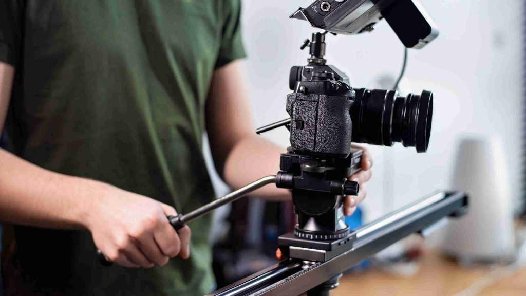 man filming with camera slider professional rig