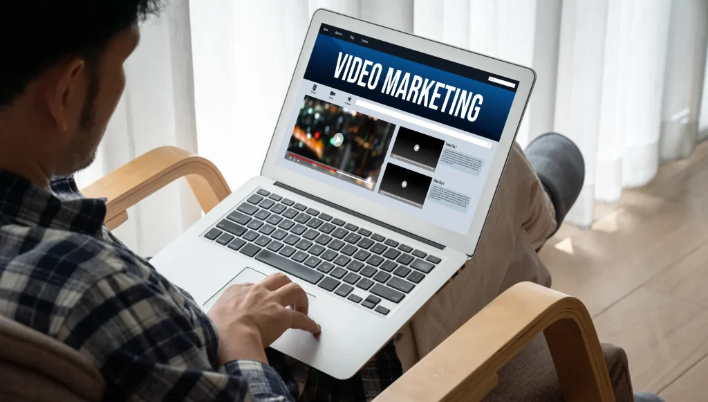 Man using laptop to create or watch online content for video marketing strategy at home