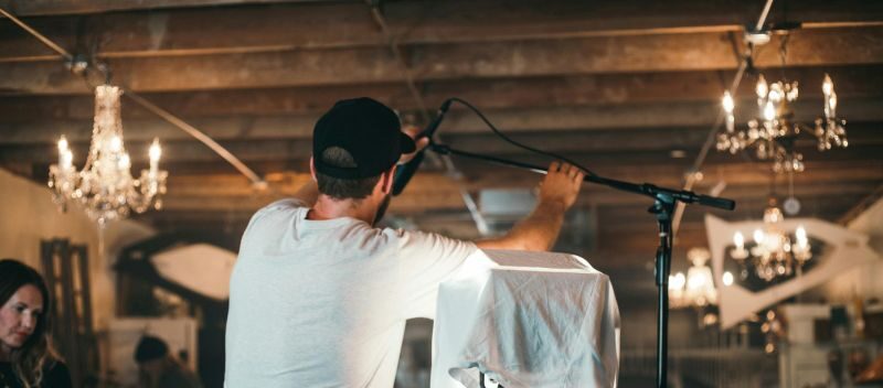 Man Fixing Microphone With Stand