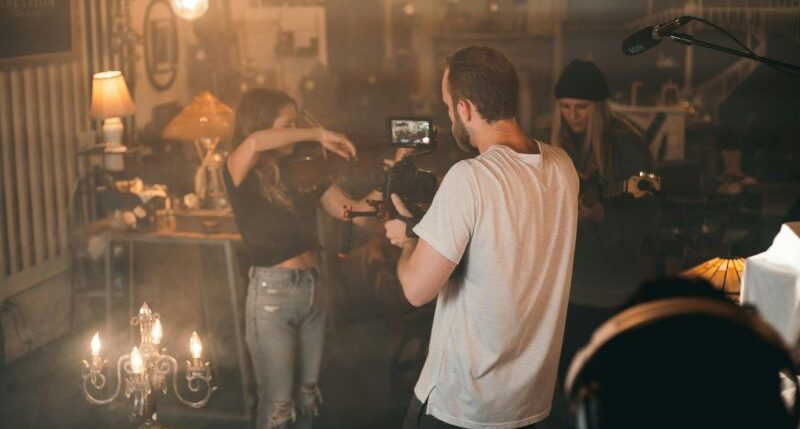 Man Taking Video of Woman Playing Violin