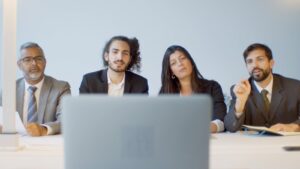 Diverse team of professionals in a meeting discussing with focus on video conferencing setup